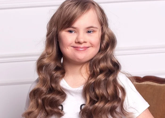 Girl with down syndrome smiling at camera