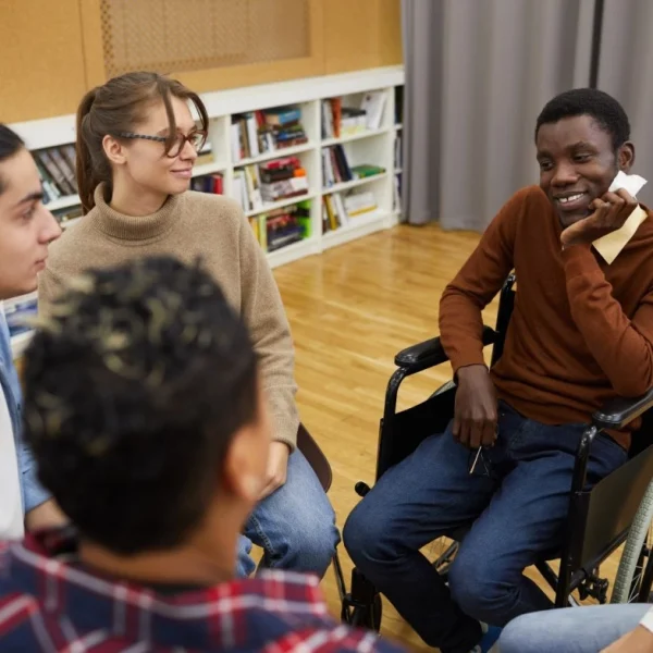 Man in wheelchair smiling with group of friends