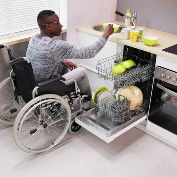 Man in wheelchair doing the dishes at home